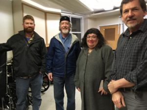 Four people standing and smiling