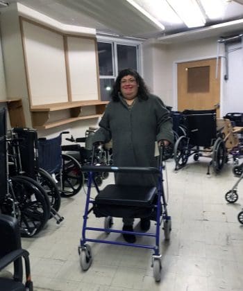 Smiling woman with rollator in a room full of DME.