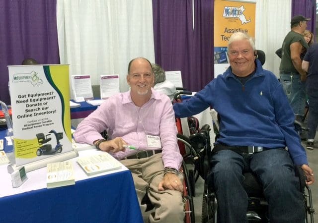 Two smiling men in wheelchairs at the MassMATCH Abilities Expo booth.