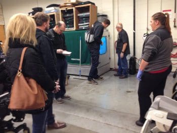 A group of adults studying the HUBSCRUB in a warehouse space.