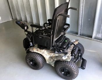 All-terrain power wheelchair with camouflage body.