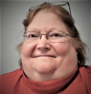 Headshot of a smiling woman with glasses.