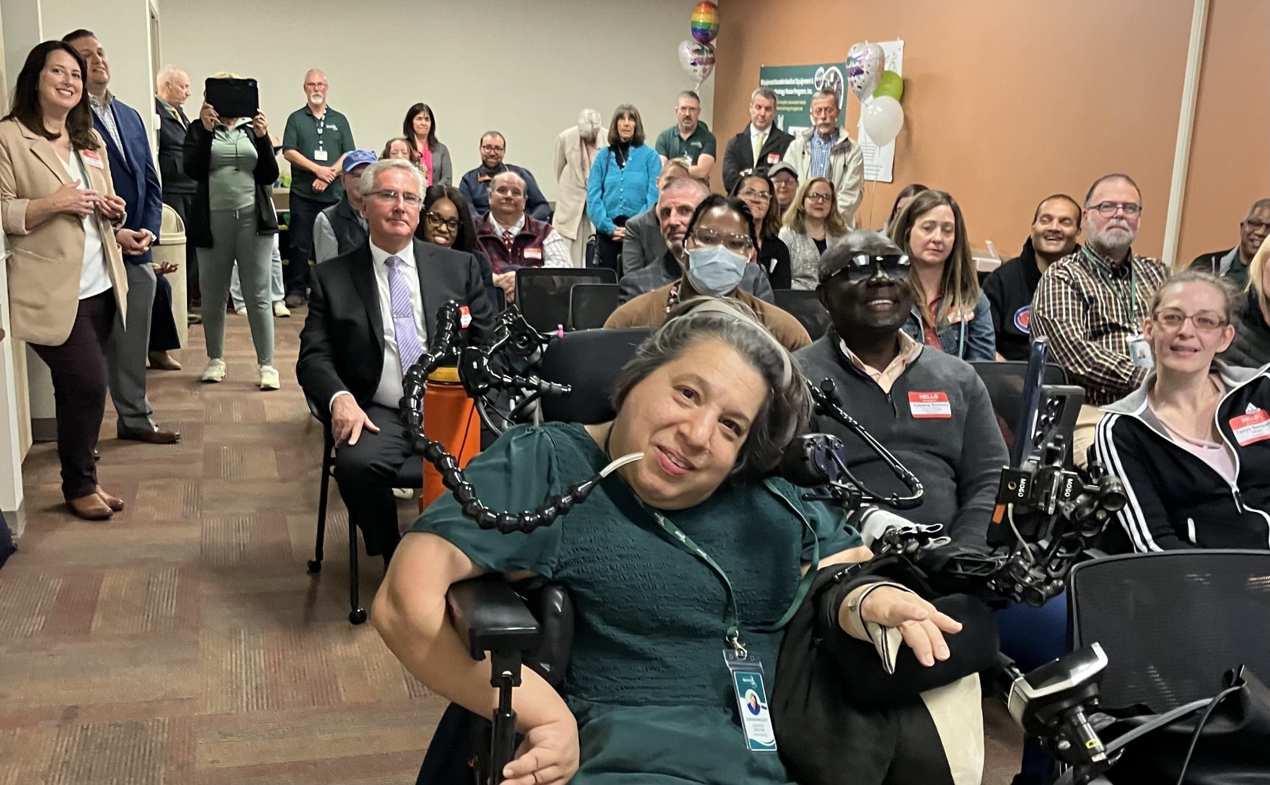 A roomful of people, some seated, some standing.