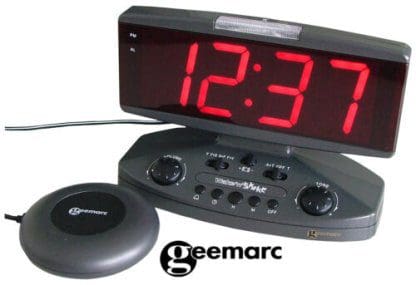 A clock with large LED display and a base with buttons and a plastic disc attached with a cord.