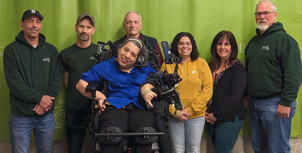 REquipment staff gathered together with CEO Adriana Mallozzi seated in her power wheelchair.